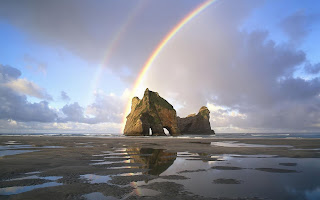 Regenboog achtergrond met eiland met rotsen