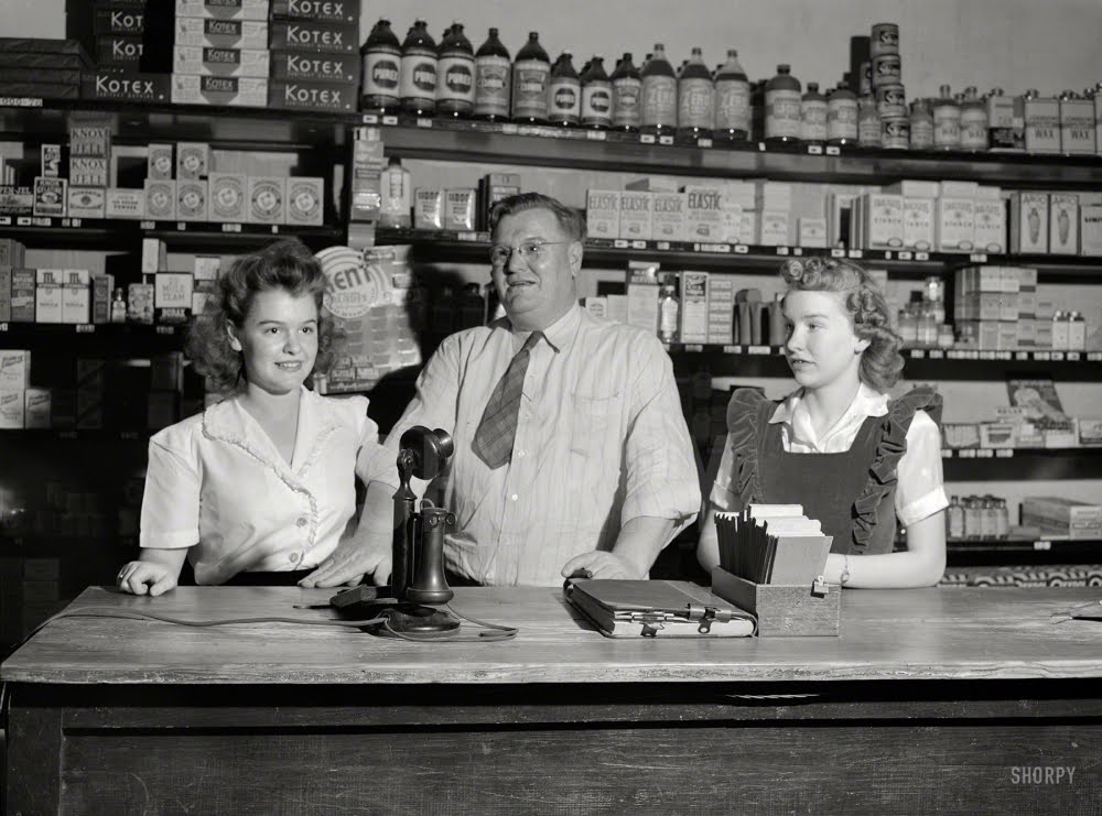 April 1943. San Augustine, Texas. Clyde Smith, grocer, with his two daughters