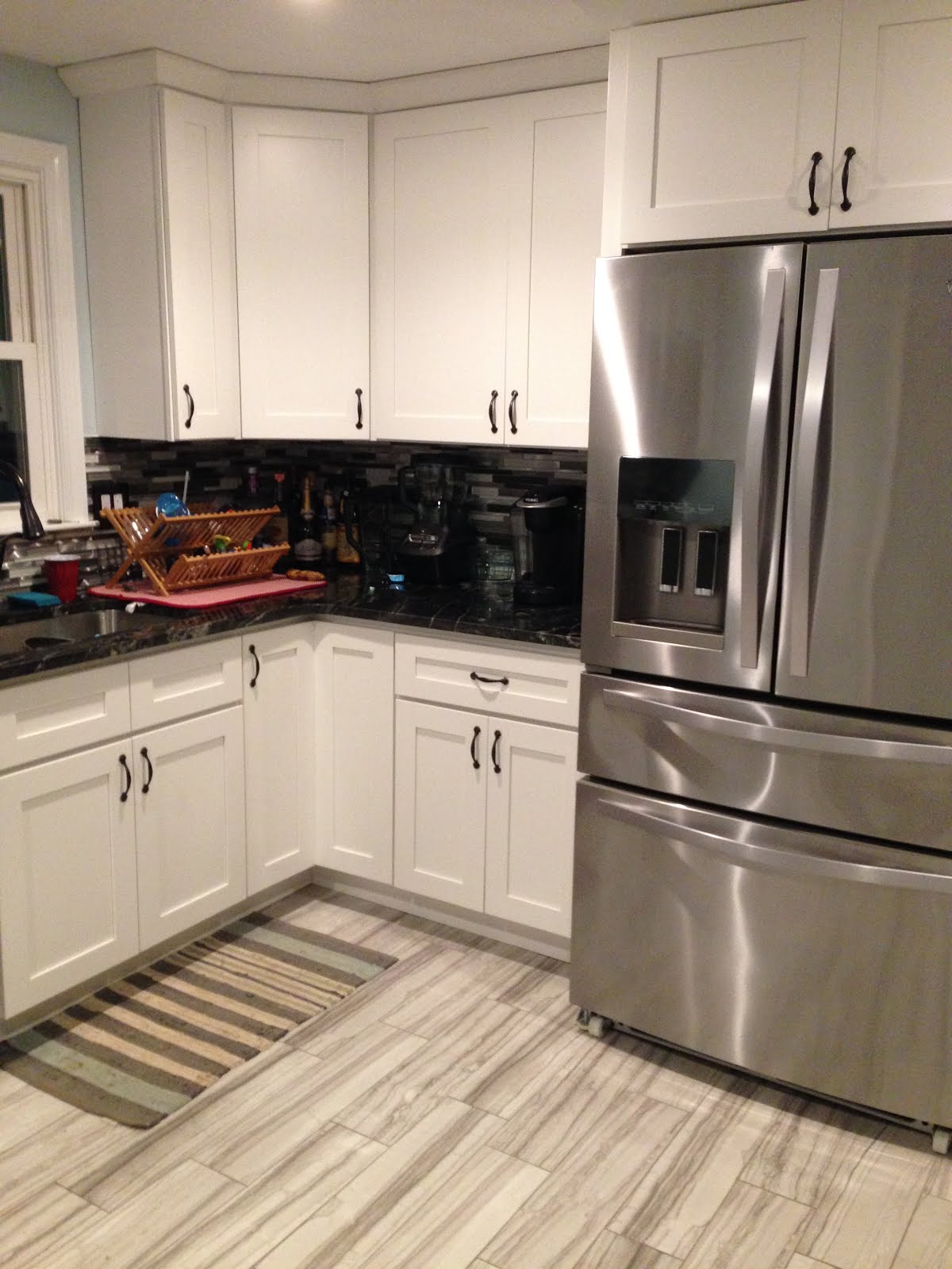 updated kitchen with white cabinets and black countertops