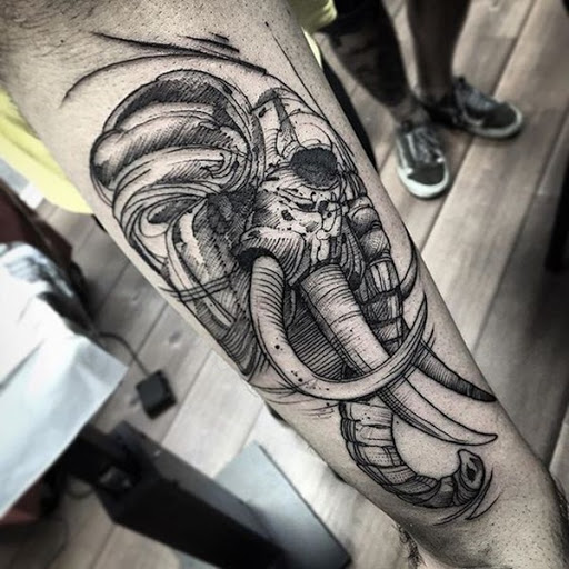 Um retrato estilizado de um elefante crânio é retratada em preto e cinza, tinta sobre o portador do antebraço.