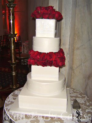 A five tier ivory pearl square and round design wedding cake with a floral