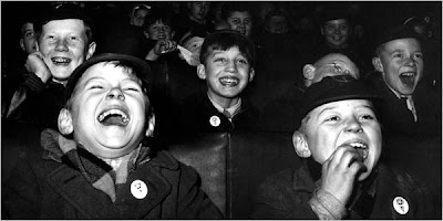 black and white photo of children laughing at a movie theater