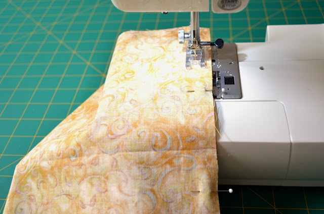 Fabric on the sewing machine, stitching the side seams. 