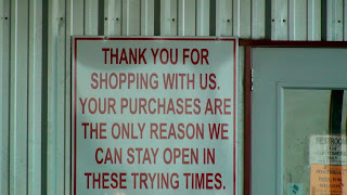 sign stating "Than you for shopping with us. Your purchases are the only reason we can stay open in these trying times"