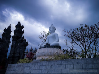 White Buddha Statue At The Front Of Garden Yard In Cloudy Day At Buddhist Monastery Bali Indonesia