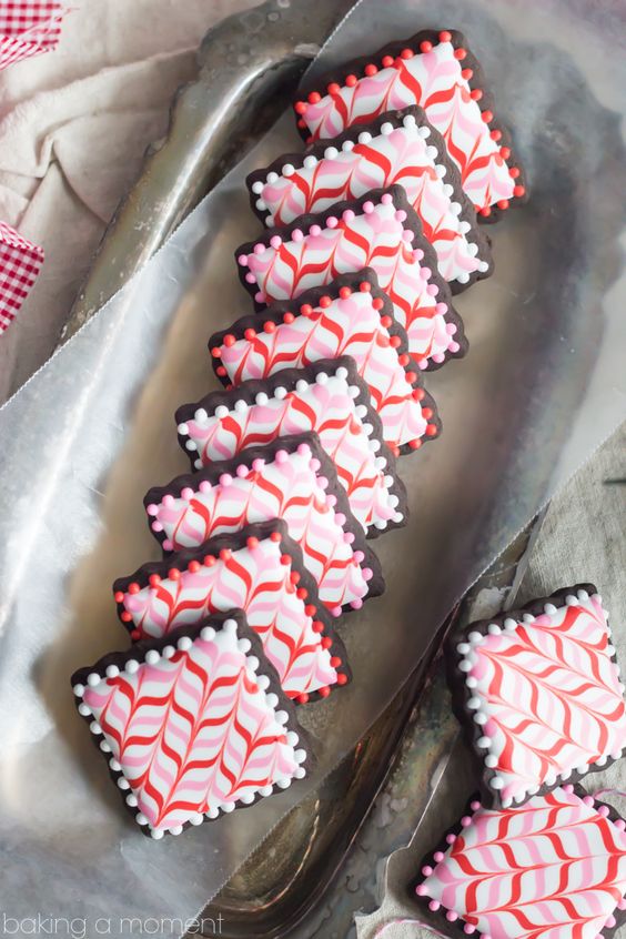 These Dark Chocolate Peppermint Sugar Cookie Cut-Outs are Decorated with Pink and Red Candy Cane Stripes of Royal Icing! Follow my Video Tutorial and enjoy this Fun and Festive Holiday Recipe.