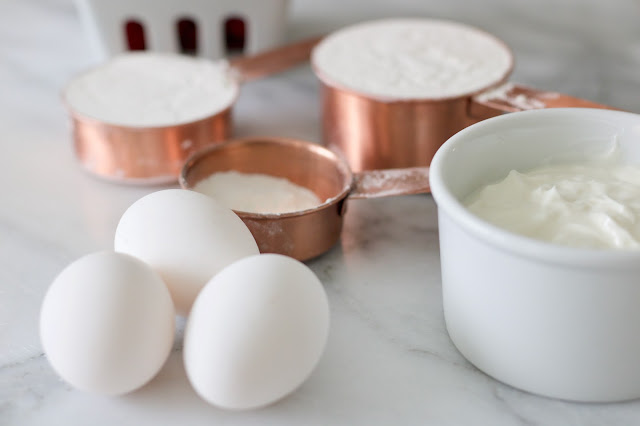 pretty copper measuring cups next to eggs and batter