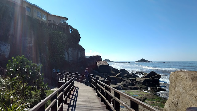 A passarela, ao fundo, a Cama de Anchieta, acima, as casas equilibradas sobre as rochas