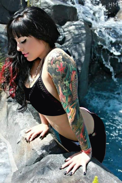Chica saliendo del agua con tatuajes de carpas