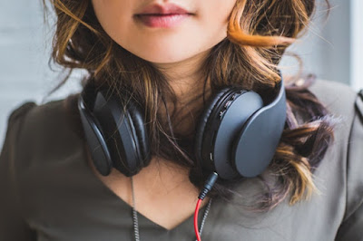 perempuan menggunakan headset untuk mendengarkan lagu menggunakan headset bass