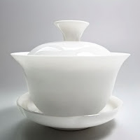 Beyaz renkli, desensiz ve sade olan kapaklı ve tabaklı porselen şekerlik