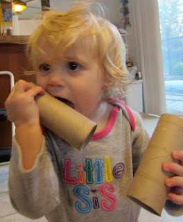 toddler chewing on toilet paper tubes