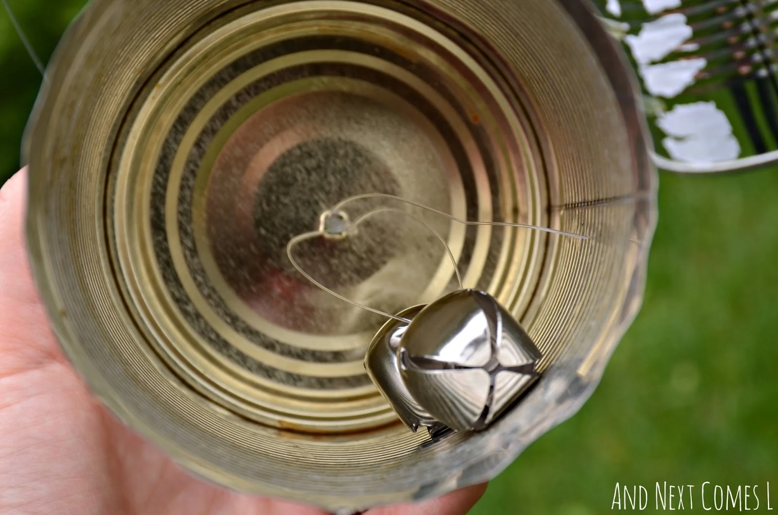 Jingle bells in a tin can on a DIY recycled outdoor music station from And Next Comes L