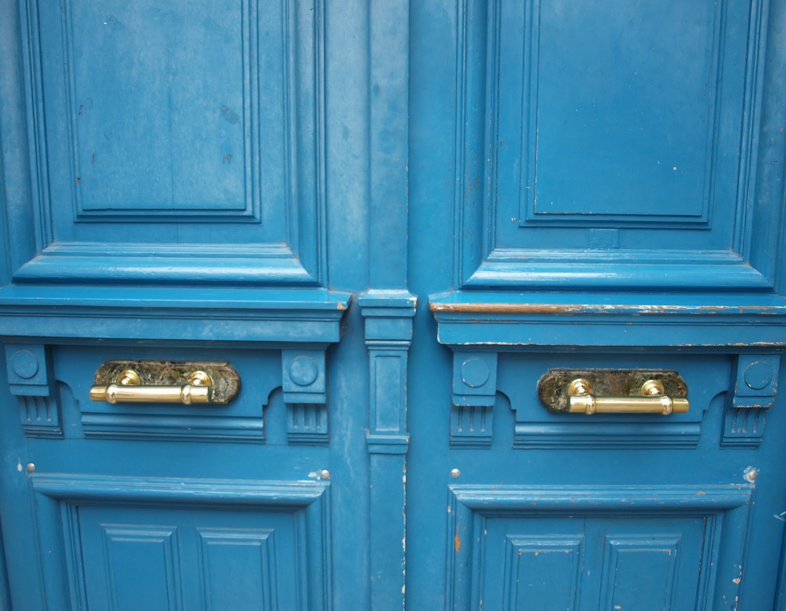 Vivid blue doors to Paris apartment with shiny brass hardware by Hello Lovely Studio