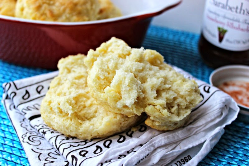 Easy Peasy Buttermilk Biscuits by Renee's Kitchen Adventures biscuit cut open to see the fluffy inside. More biscuits in the background. 