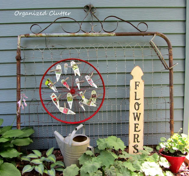 Old rusty gate, bike wheel plant tag organizer