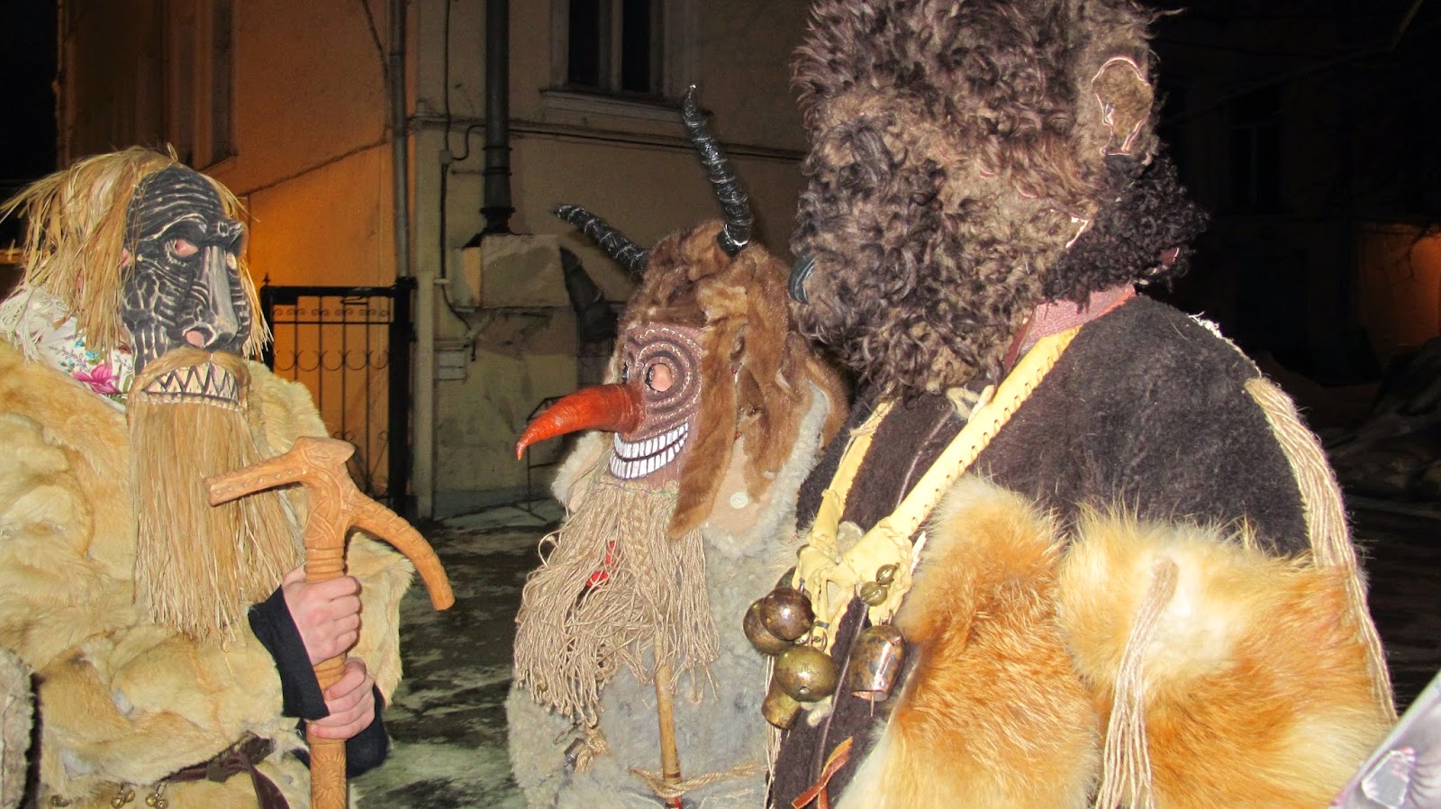 На переднем плане картины на фоне фигур ряженых с мазанными сажей лицами