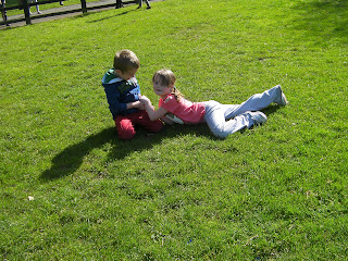 boy and girl wrestling for ownership of football
