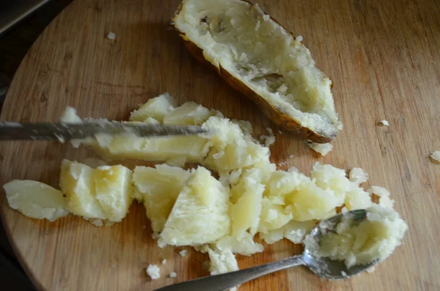 Scoop out insides of baked potatoes.
