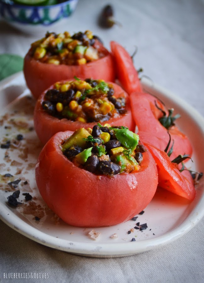 Tomates rellenos ensalada texmex en fuente porcelana blanca, fondo madera, cilantro, ingredientes