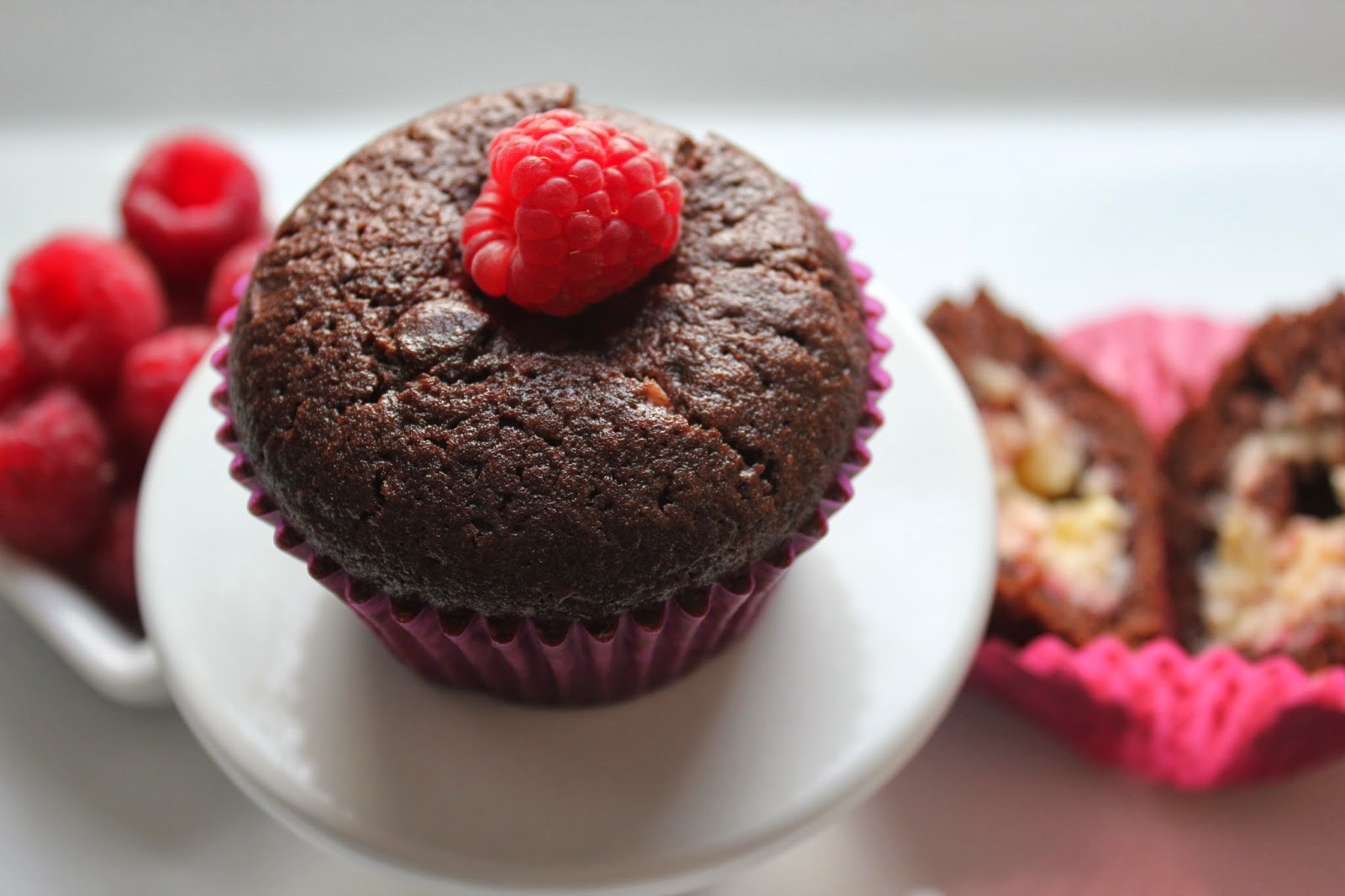 Chocolate-raspberry cheesecake muffin with raspberries and cut-open muffin