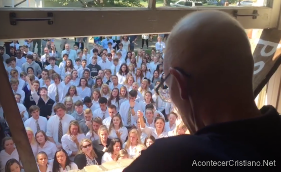 Estudiantes cantando alabanzas frente a la casa de su profesor