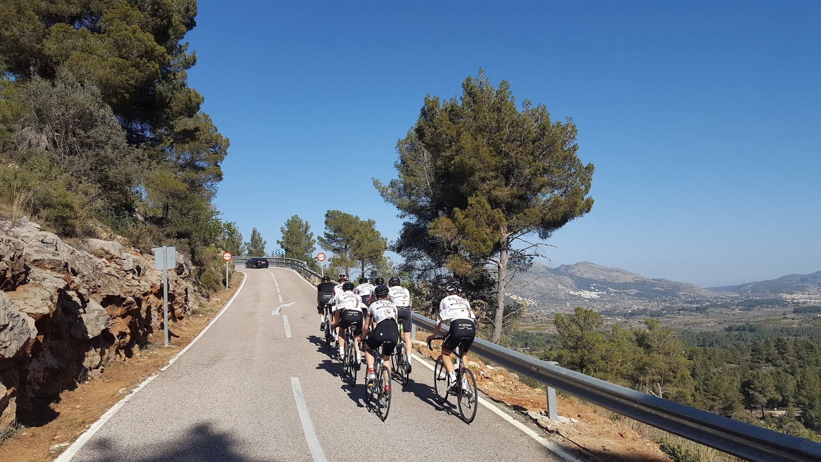 Cyclists climbing to the summit of Coll de Rates from Parcent