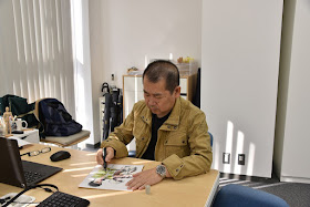 Yu Suzuki signing an illustration