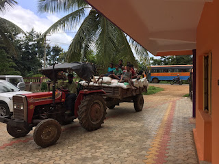 The boys riding the tractor home after buying materials for the children farm