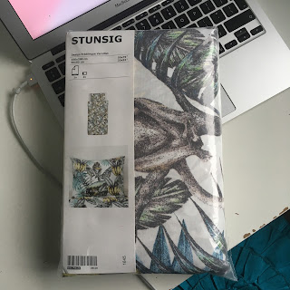 A package containing a duvet cover, which is printed with monkeys holding bananas and cameras