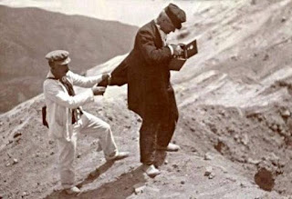 Mercalli collecting data on the edge of the crater of Vesuvius, with an aide on hand to keep him from falling