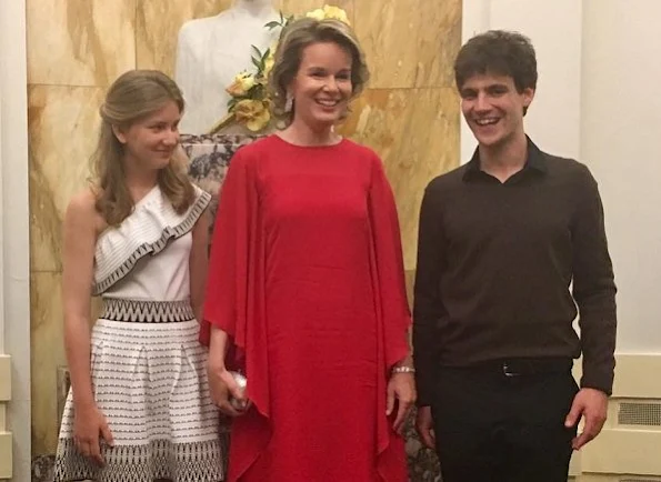 Queen Mathilde wearing a new red dress at a final of the Queen Elisabeth Music Competition. Crown Princess Elisabeth wore a white shoulder open embroidered dress