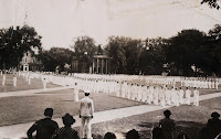 A photograph showing a series of men in white uniforms on the green.