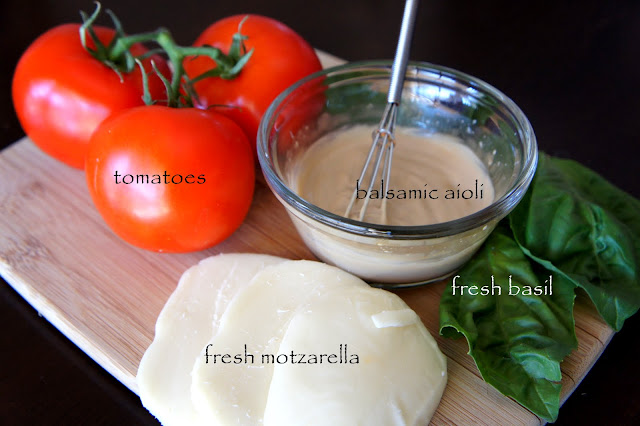 A display of needed ingredients for the Turkey Caprese Panini, tomatoes, balsamic aioli, fresh mozzarella and fresh basil