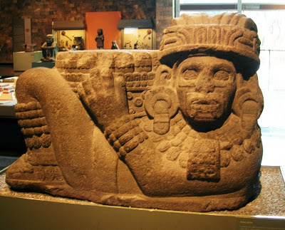 Chac Mool, holding a pillar like object emerging from his stomach. National Museum of Anthropology in Mexico City
