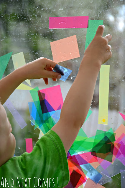 Young child placing colored transparencies on a window