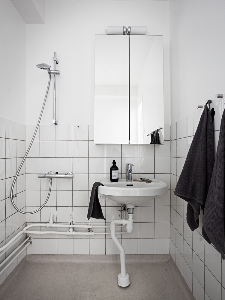 Painel de marcenaria abriga adega, TV e oculta portas neste apê de 170 m²