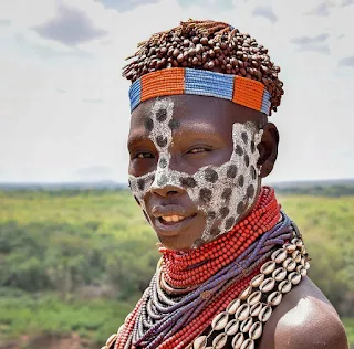 Wearing cowrie shells and glass beads a Karo Woman in Ethiopia is beautiful