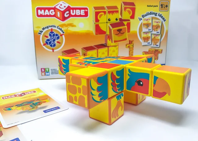The building blocks together in the shape of a bird in front of the box and next to the instruction cards