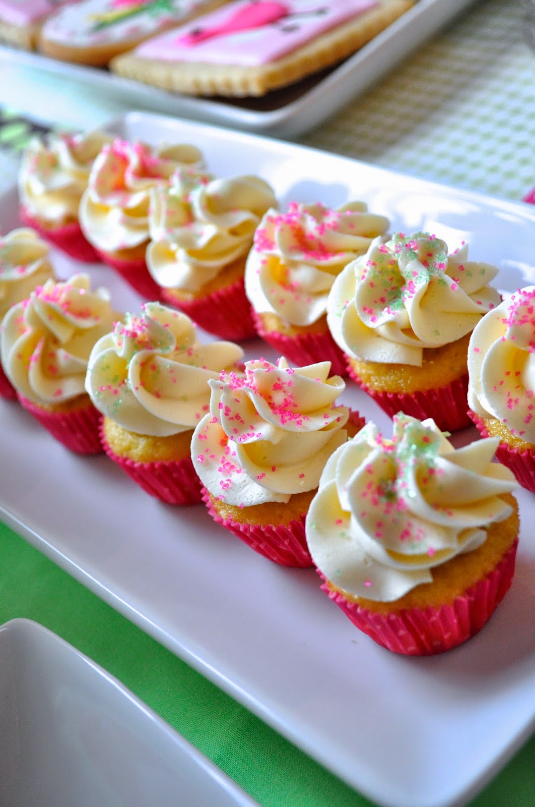 more mini cupcakes decorated with easy vanilla buttercream and pink sugar sprinkles