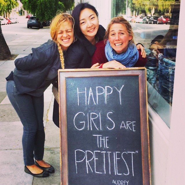 three girls in front of sign happiest girls are the prettiest lifestyle of beauty