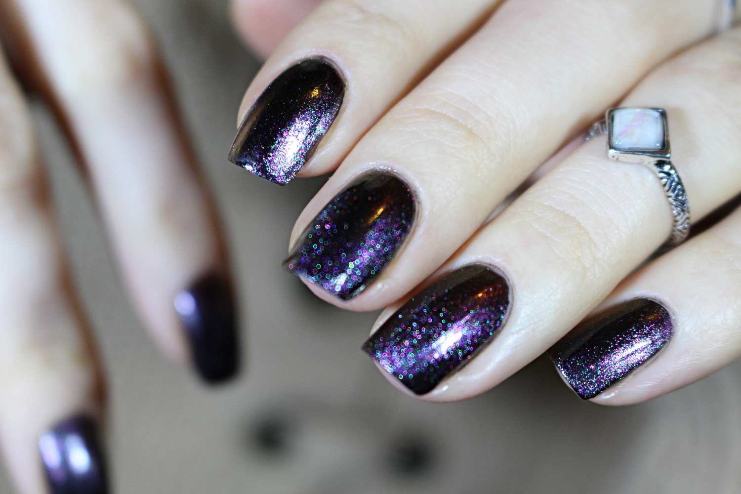 close-up of dark purple nail look with cat eye nail polish