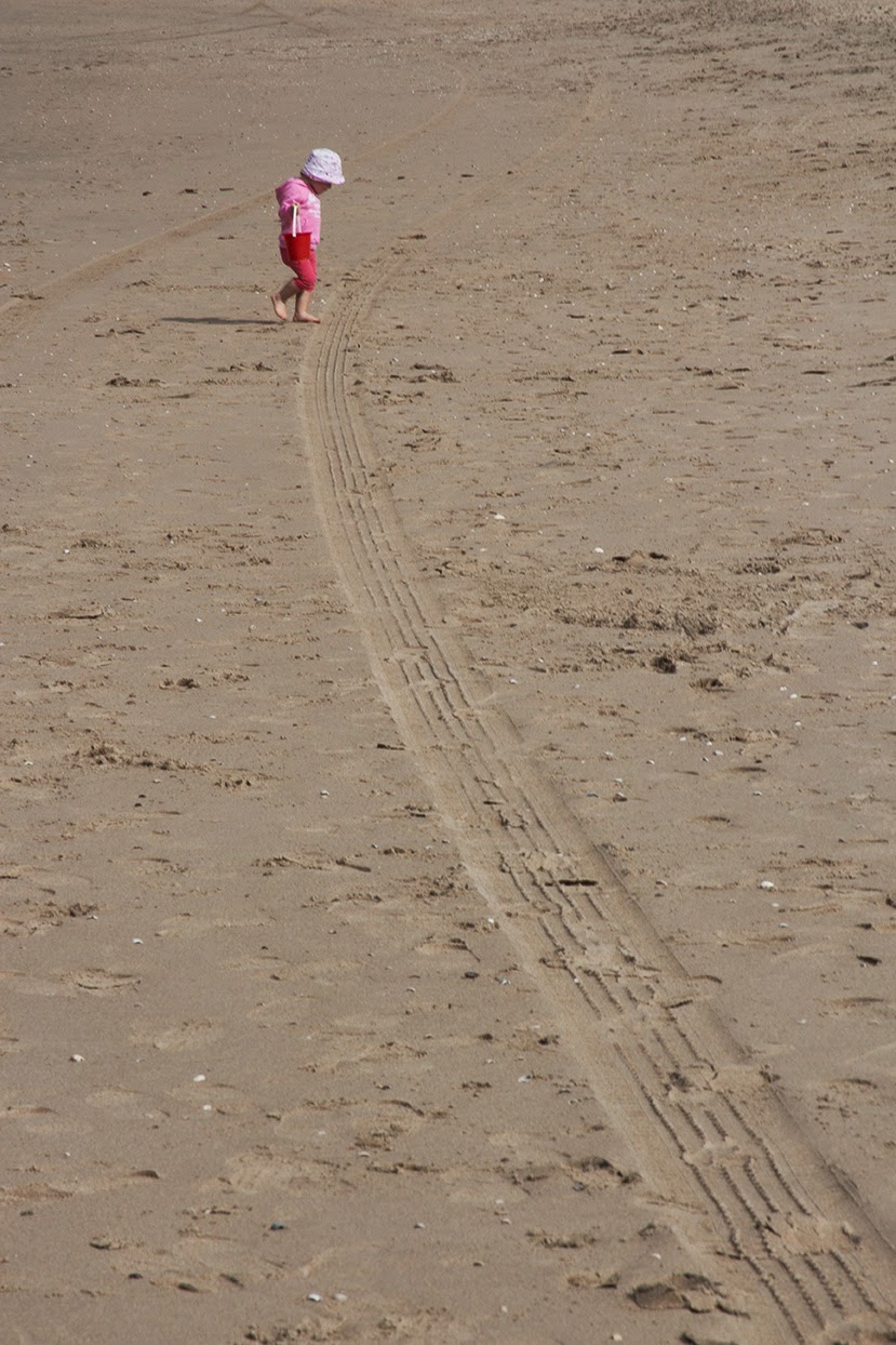 little girl in pink crossing the beach