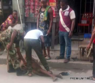 Photos: Two soldiers caught on camera beating a commercial tricycle rider in Lagos after stripping him naked, threatens to cut off his penis