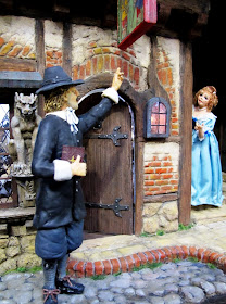 Two figures outside a one-twelfth scale miniature mid 17th-century inn.