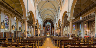 Interior of Whitefriar Street Church in Dublin, Ireland Interior view of the white arches, goldtone pews and stained glass windows of Whitefriar Street Church in Dublin, Ireland