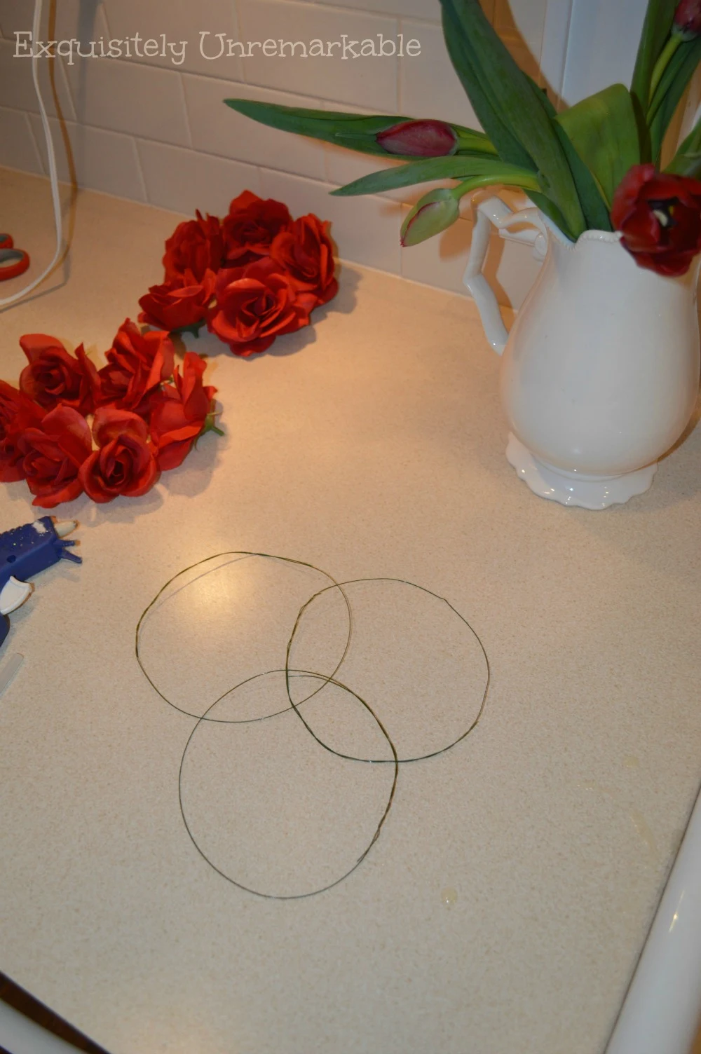 Supplies to make DIY floral candle rings, wire, roses and glue gun