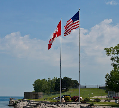Canadian Flag flying alongside the American flag photo by mbgphoto