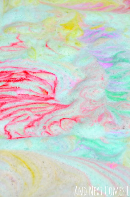 Close up of tie dye rainbow soap foam bubbles sensory play bin activity