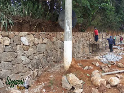 Construção do muro de pedra bruta sendo o tipo de pedra moledo com cores variadas sendo tipo de muro de pedra com junta seca sem massa nas juntas. Muro de pedra na cidade de Joanópolis-SP.